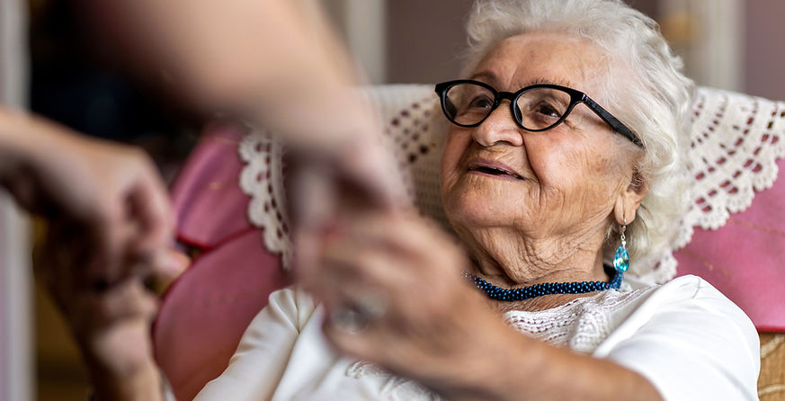 Een vrijwilliger reikt een helpende hand aan een oudere bewoner
