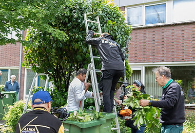 BelKlus-vrijwilligers voeren samen een klus uit in de wijk